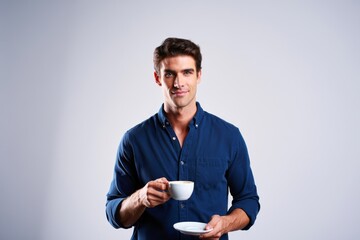 A Confident Man Holding a Cup of Coffee, Exuding Charm and Style in a Studio Setting with a Neutral Background