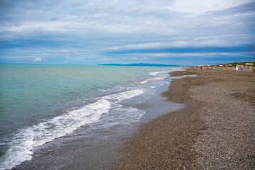 Beach in Tuscany with sea and cloudy sky