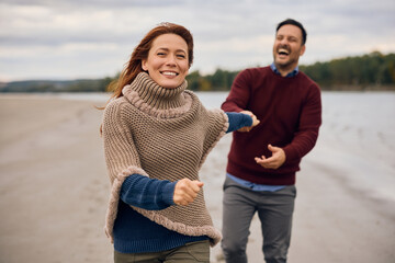 Carefree woman running with her boyfriend in nature in autumn.