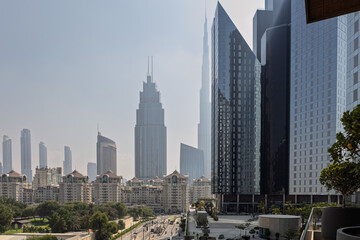 Daytime view of massive modern glass skyscrapers towering over low-rise traditional residential...