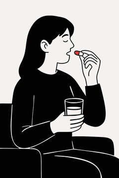 Woman taking pill with glass of water as part of healthy lifestyle