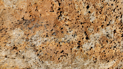 Surface of a rust-colored, porous lava rock, also called reddish-brown scoria, is a lightweight, vesicular volcanic rock with a spongy texture, formed from cooled lava