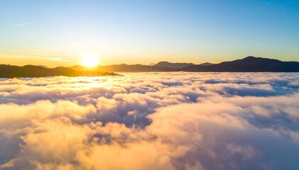 Fototapeta premium Breathtaking sunrise illuminates a sea of clouds above mountain peaks, casting golden light across the serene landscape, inspiring peace and wonder