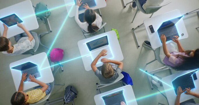 Children Interacting With Laptops, Tablets in Modern Classroom, Surrounded by Glowing Digital Connections. Concept Technology Integration and Prevalence of Artificial Intelligence. Rotating Top View.