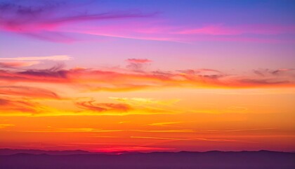 Stunning vibrant sunset paints the sky with fiery oranges, pinks, and purples over silhouetted mountains, creating a dramatic and breathtaking natural spectacle.