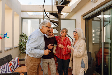 Obraz premium A group of four friends stand and laugh while three of them hug each other