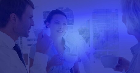 Standing colleagues in business attire sipping coffee from ceramic cups by large window on break