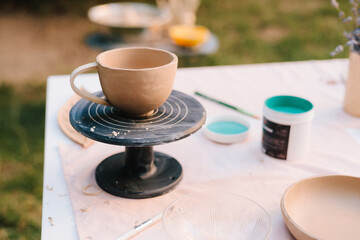 Hand painting blue pain on ceramic bowl close-up. artist carefully applies paint with a brush on clay bowl, showcasing the creative process of ceramic painting and the art of handcrafted pottery.