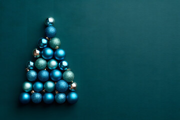 Fototapeta premium Modern Christmas Tree Made of Blue Ornament Balls Isolated on a Dark Teal Background Minimalist Festive Concept with Copy Space