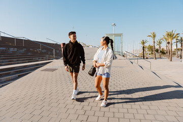 Fototapeta premium A man and a woman walk and smile while talking and looking at each other