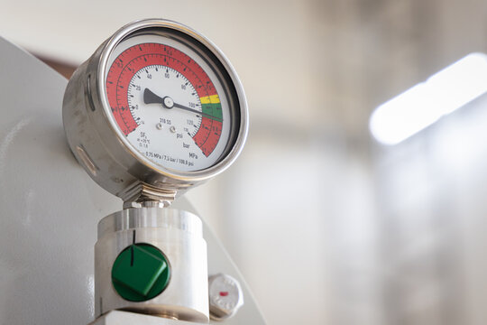 Close-up of a pressure gauge installed on high-voltage gas-insulated switchgear (GIS) inside a power plant, used to monitor SF6 gas levels, ensure safety, and maintain electrical system efficiency