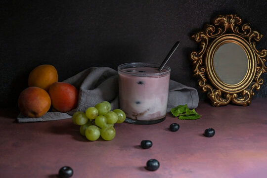 Perfectly ripe blueberries and a blueberry and oatmeal smoothie on a treated pine wood table