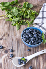 utumn still life with blueberries on a thick black felt background and a cobalt blue glazed ceramic spoon
