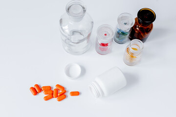 colored pills in glass bottles on white background