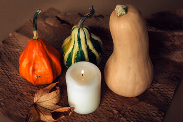 Pumpkins, candle and autumn leaf on textured craft paper background. Thanksgiving, Halloween concept. Top view