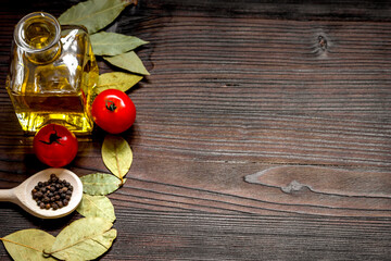 jar with oil and tomatoes on wooden background top view