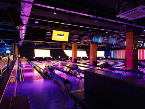 Vibrant neon King Pins bowling alley with glowing lanes, pins, and screens for a lively night out