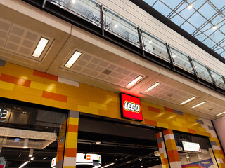 Naklejka premium Lego store entrance with colorful yellow brick exterior and modern glass balcony in mall