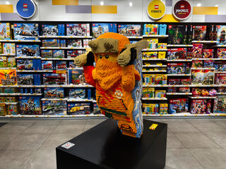 Naklejka premium Plastic brick sculpture of Ninjago in a LEGO store display, bright and colorful