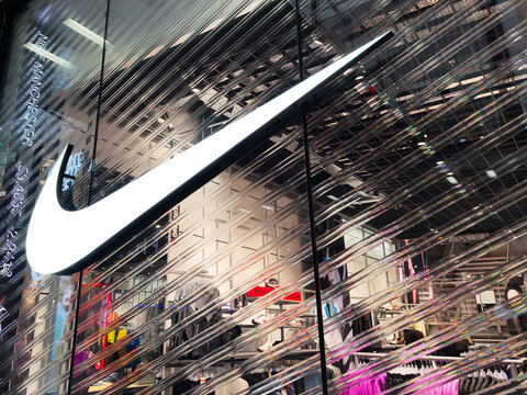 Nike storefront with large swoosh logo and modern glass reflections in a retail store