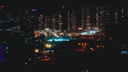 The gate of Ankara, Türkiye surrounded by city lights and big apartments at night time