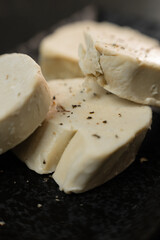 A striking close-up of luxurious French foie gras, beautifully presented on a sleek black marble plate, emphasizing the gourmet texture and elegant contrast