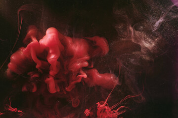 Abstract colorful smoke, dark background. Moving flow of red paints, fluid art
