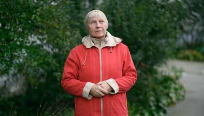 Older woman in red jacket enjoying nature.