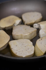 Seared foie gras sizzling in a hot frying pan with rendered fat, creating a golden-brown crust for a classic French gourmet cooking process