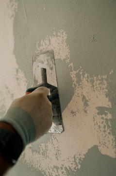 Plastering wall with hand trowel during interior house repair