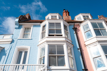 Tall townhouses seen in pastel colours with there large sash windows. The houses over look the...