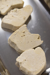 Close-up of Raw, Uncooked Foie Gras Lobe or Goose Liver on a Cutting Board in a Professional or Gourmet Kitchen, Ready for Culinary Preparation
