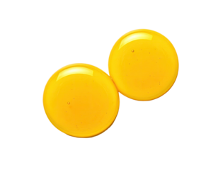 Two vibrant golden yellow, translucent drops, top-down view, against a solid black backdrop