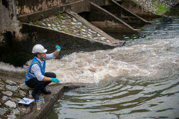 Wastewater treatment worker is collecting samples of water from a public well