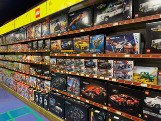 Naklejka premium Moscow, Russia, August 28, 2025: LEGO store shelf filled with variety of LEGO sets, from classic cars to intricate Technic models and popular collaboration. Endless creative building possibilities