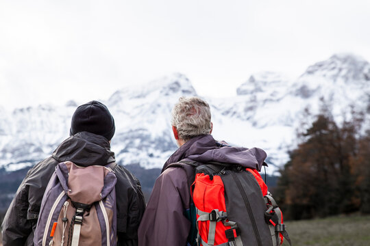Two friends walking and talking on a winter hike in Catalonian Pyrenees
