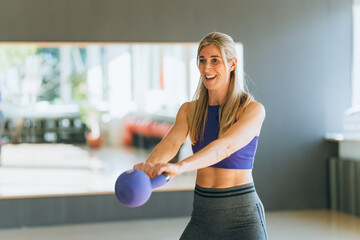 Active lifestyle woman wearing sportswear training with gym equipment focusing on fitness strength energy and healthy living goals