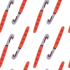 Red crochet hooks repeating in seamless pattern for craft, handmade projects and textile backgrounds.