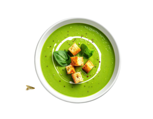 A top-down view of a bowl of vibrant green soup, garnished with croutons, basil, and cream swirls