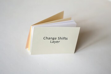 Minimalist open booklet with layered pages displaying the word Change