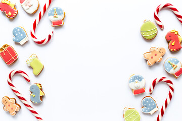 Festive composition of Christmas and New Year gingerbread cookies and Christmas Candy Canes on white background, top view. Greeting concept