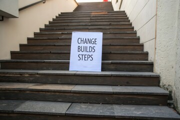 Motivational sign with Change Builds Steps on an ascending staircase