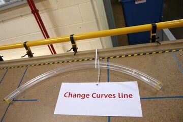 Transparent curved rod arranged above a card showing line change