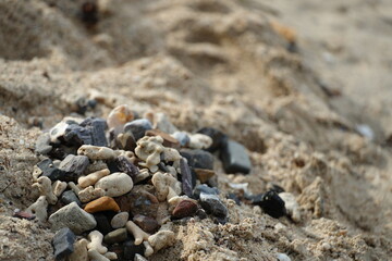 Small pile of stones and coral fragments on sandy beach, showing the natural beauty and simplicity of seaside nature.