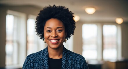Smiling woman with curly hair stands in a bright room showcasing confidence and warmth