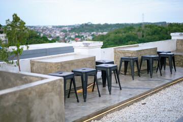 Obraz premium Contemporary Outdoor Seating Stools Arranged on a Rooftop Terrace Landscape