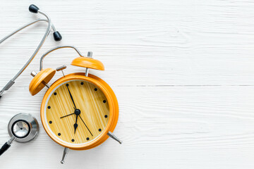Stethoscope and vintage alarm clock, top view. Time for medical checkup
