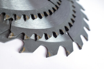 Close-up of circular saw blades with sharp metal teeth on white background, industrial cutting tool used in woodworking, metalworking, and mechanical design projects for precision engineering visuals