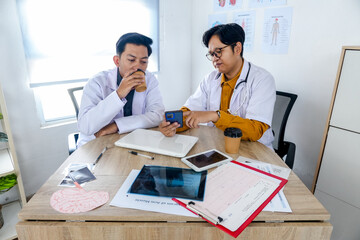 Two Confident Doctors Collaborating on Patient Care Over Coffee Reviewing Test Results and X-Rays in Modern Clinic