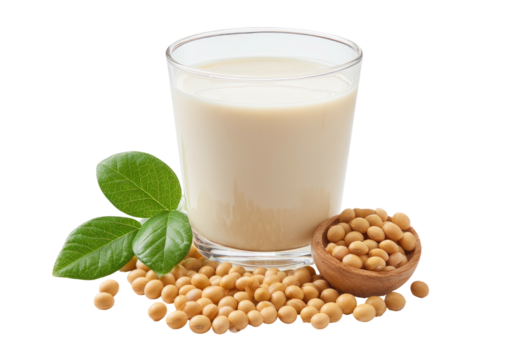 Beverage in glass next to soybeans and leaves on dark background